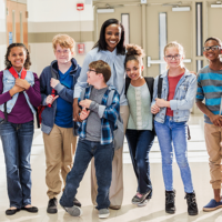 School Principal in Hallway with students, happy